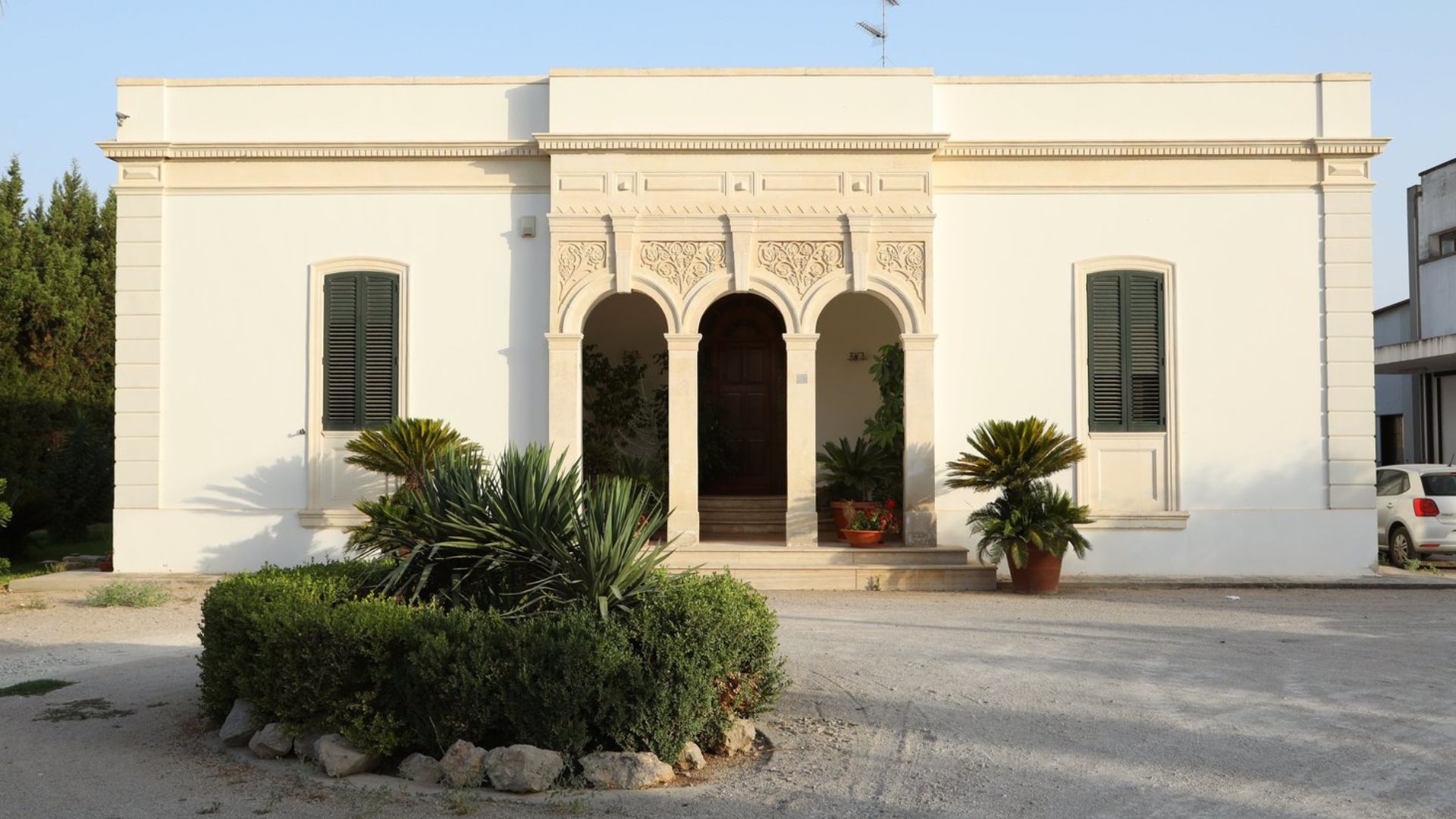 The Cantina Petrelli winery, an old building in Apulia, Italy. The image shows the building entarnce, as well as a blue sky in the background.