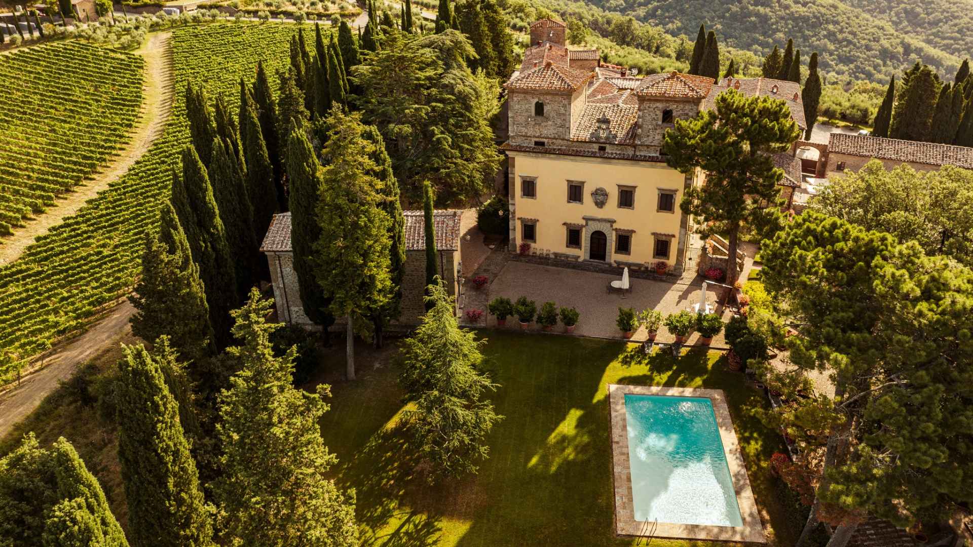 Castello di Albola winery and vineyard. The photo shows an old building and swimming pool. The photo was taken from above and 