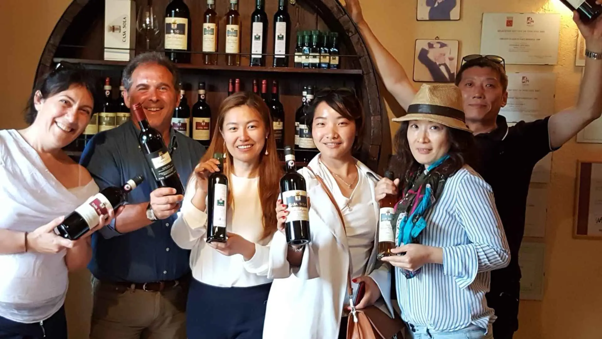 A couple of people posing with wine bottles from the Casa Sola winery.