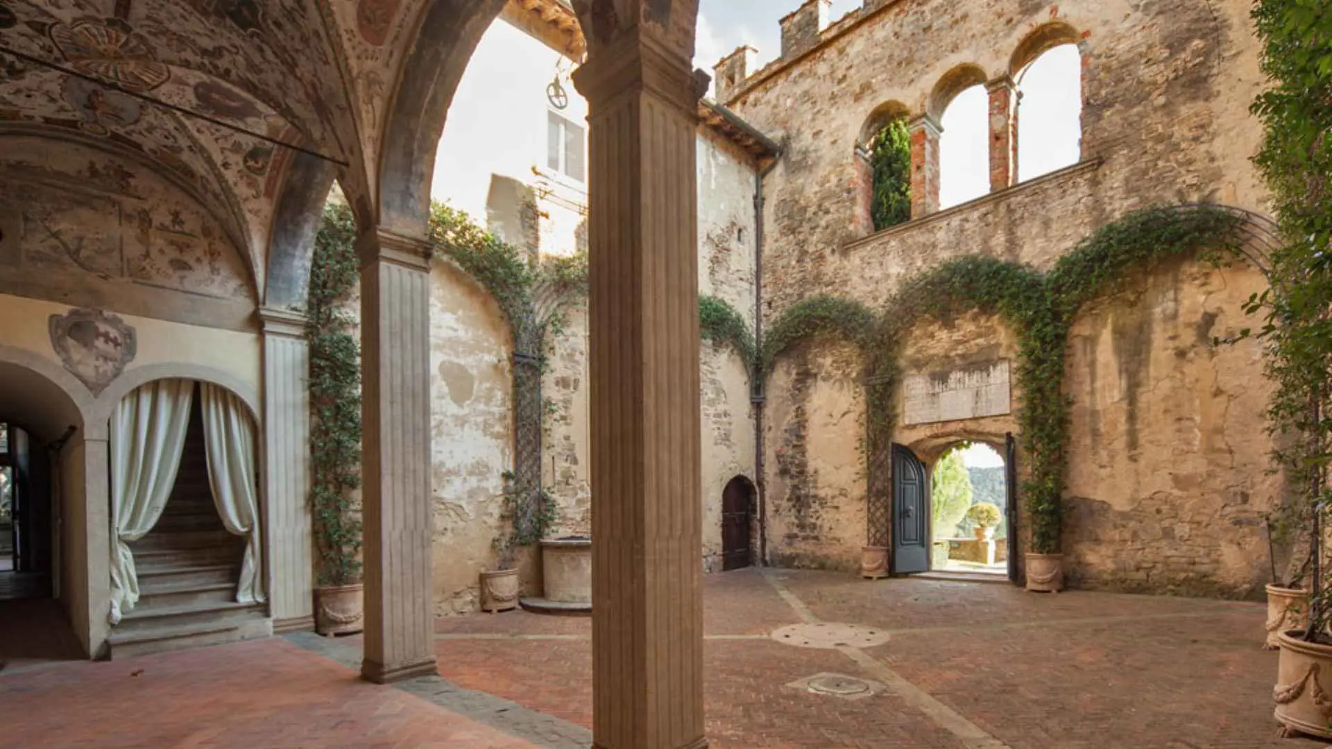 A beautiful inner courtyard of the Castello della Pneretta winery, with vines growing on some of the arches.