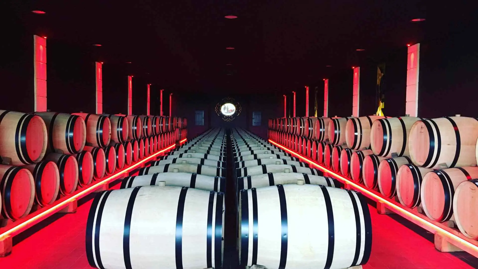 Château Destieux wine barrels can be seen in the middle, with two rows, as well as two rows on each side. There is red lighting everywhere, so it looks rather interesting.