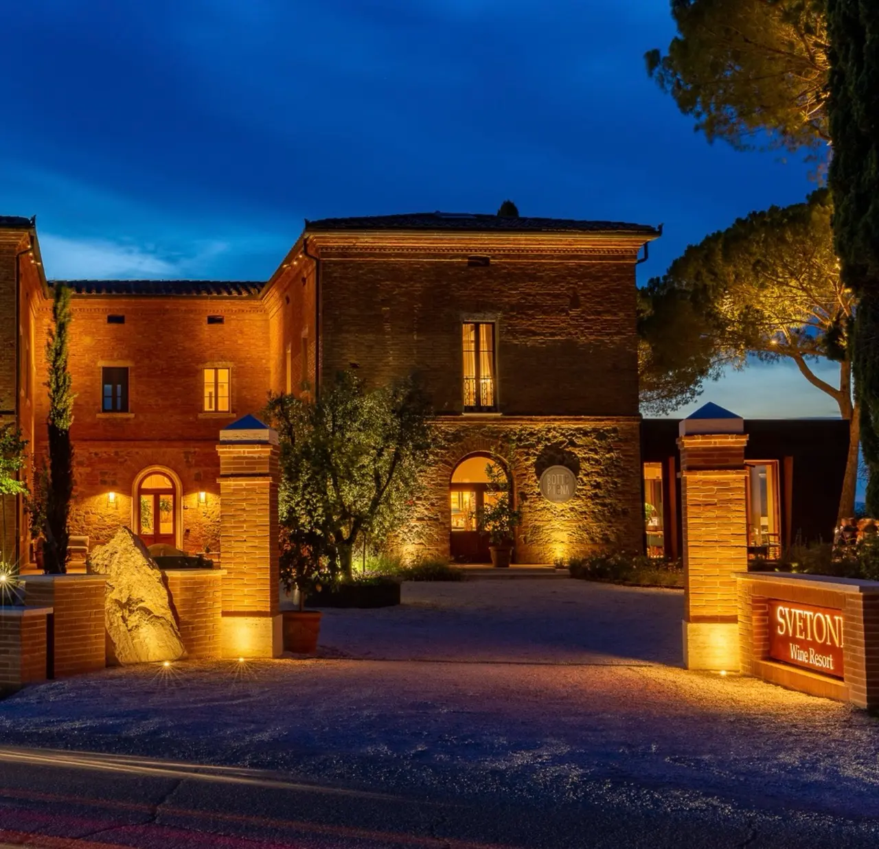 The Fattoria Svetoni or Svetoni Wine Resort, taken during the night. The building is old, but beautiful. The lights are warm-colored and the skyline shows a post-sunset nighttime.
