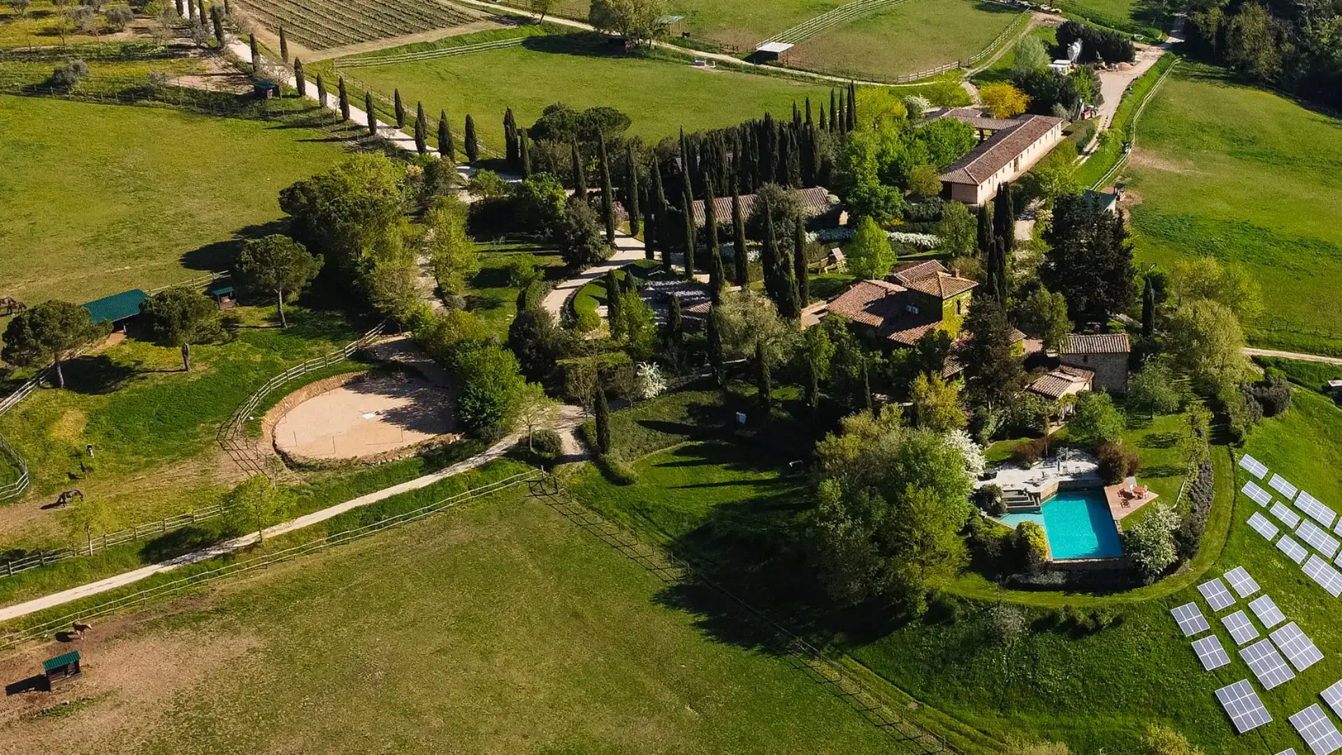 The Tenuta Degli Dei (Estate of the Gods is a picturesque winery . The iamge shows the estate, surrounded by all sorts of greenery, from vineyards to evergreen trees.